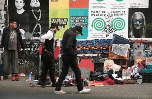 Residents lay out their few possessions on blankets to sell for extra cash