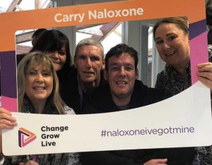 Naloxone activists pose with a sign