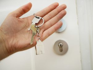 A hand holding keys to a door