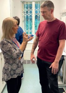 Pamela demonstrates an aerochamber to recovery worker Chris.